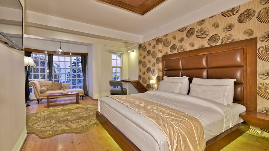 Suite with a king size bed and a living area at DLS Hillcrest Resort, Shimla.